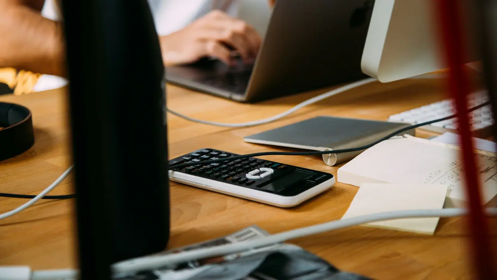 Un poste de travail de cabinet : ordinateur, calculatrice et documents.