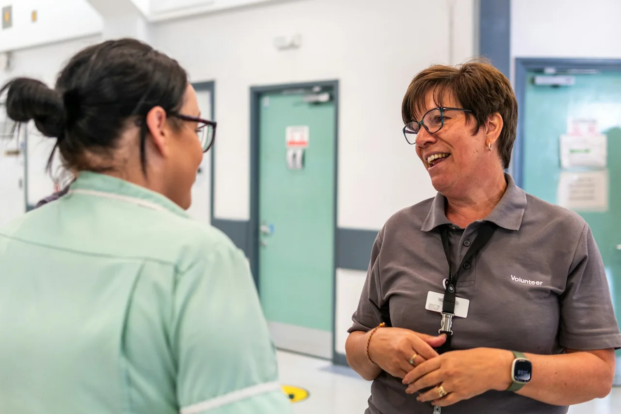 Deux professionnelles d'un établissement échangent dans un couloir de service.