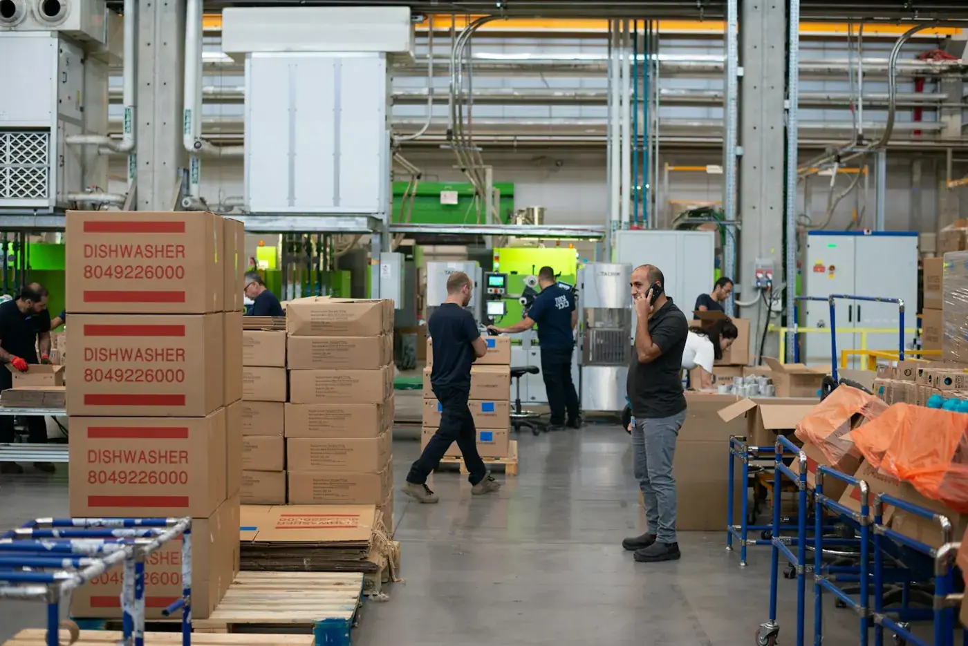 Un responsable au téléphone au milieu des cartons d'un entrepôt de production.