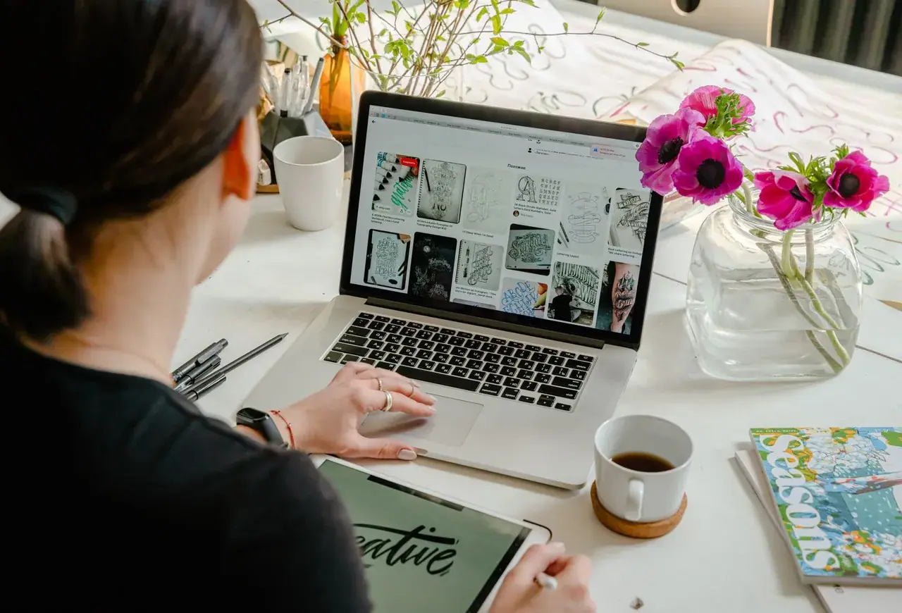 Une personne crée des visuels sur son ordinateur et sa tablette graphique.